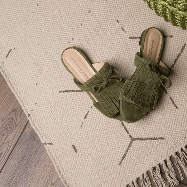 Detailaufnahme Designteppich in creme und grau mit Fransen von heineking24